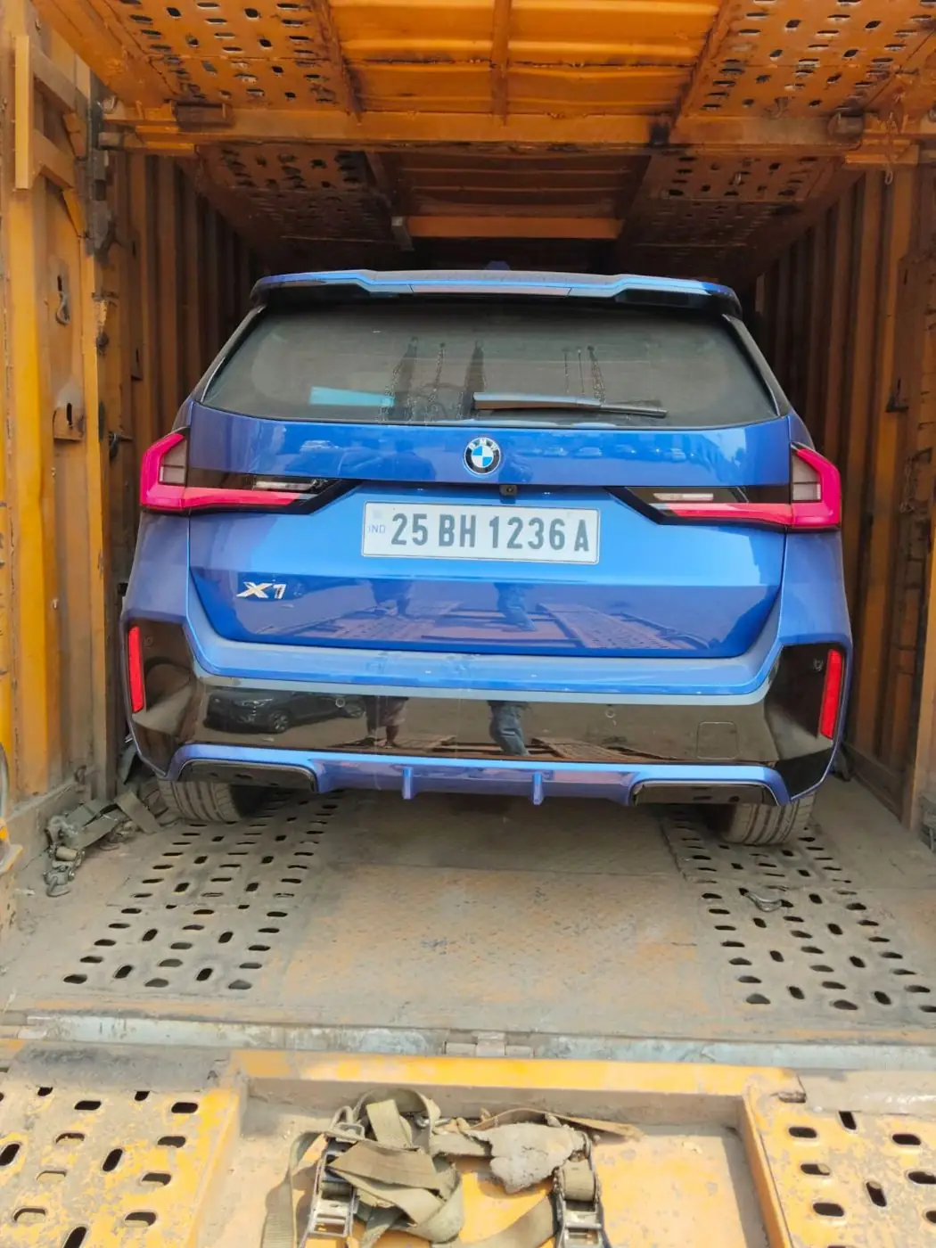 Blue SUV loaded inside the car carrier
